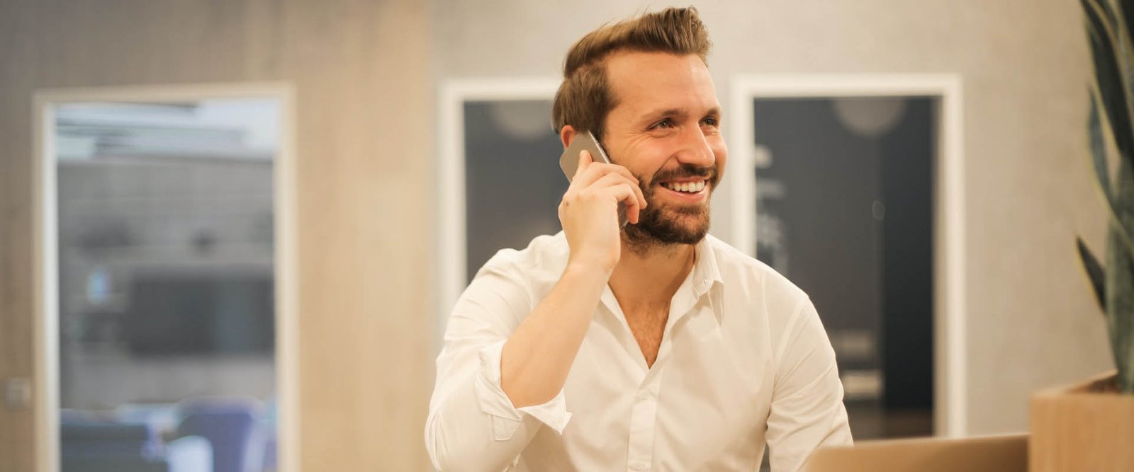 A man talking on the phone, smiling